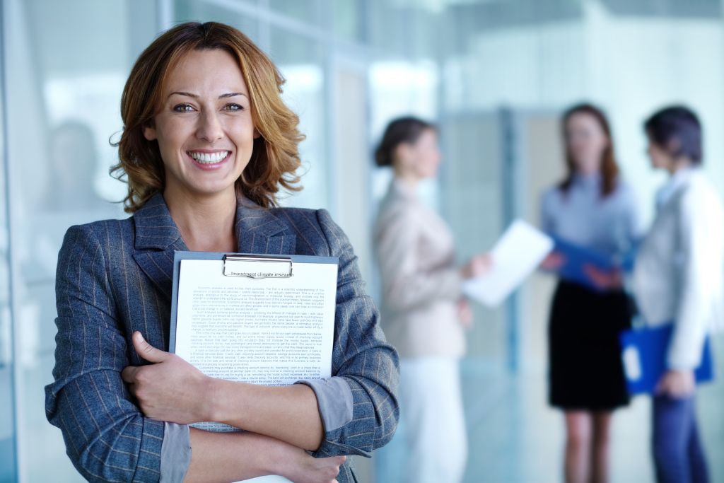   woman smiling holding a clipboard