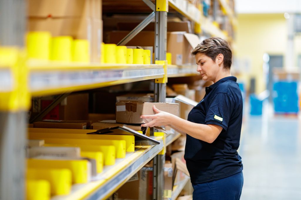 person loading boxed on shelf